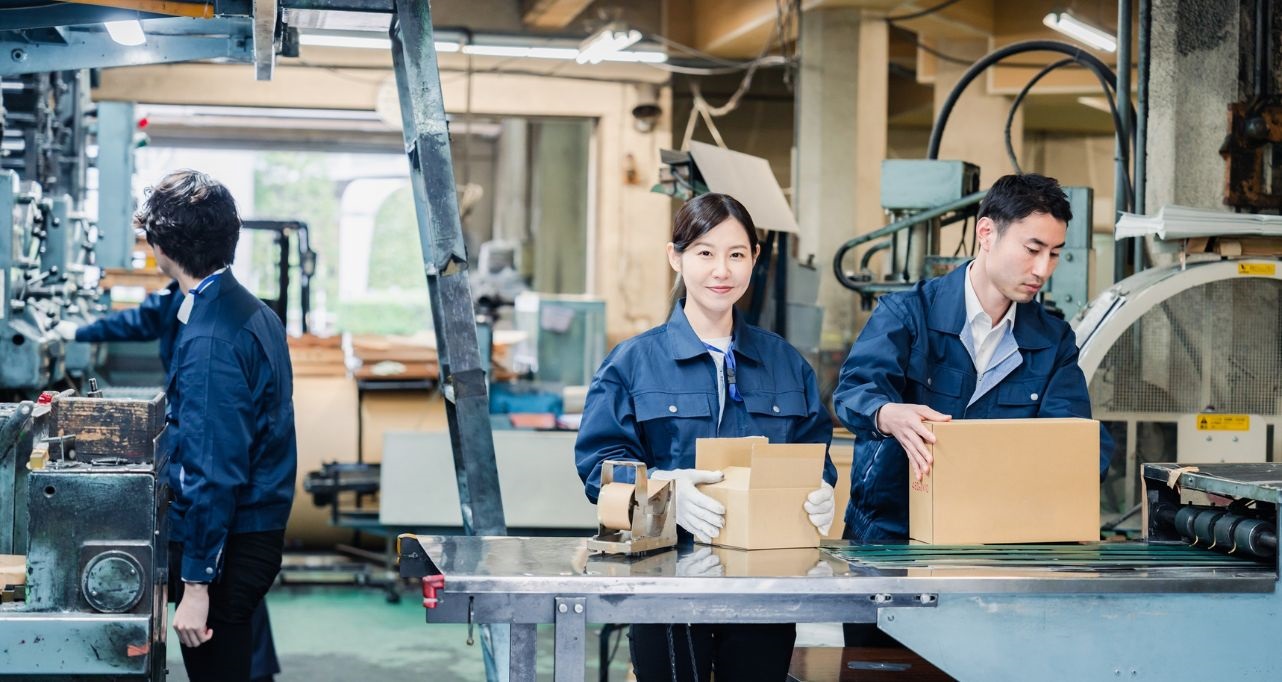 Industrial packaging and assembly line with workers in uniform managing production tasks