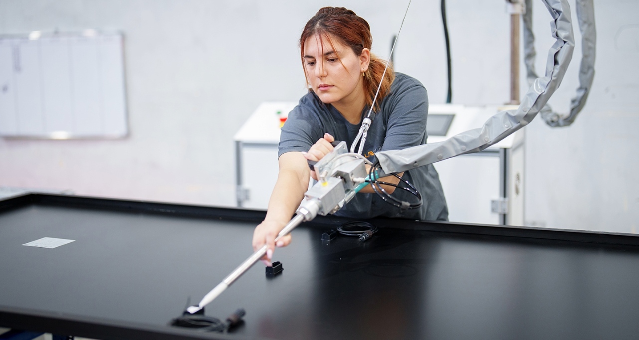 female worker operating equipment in industrial setting
