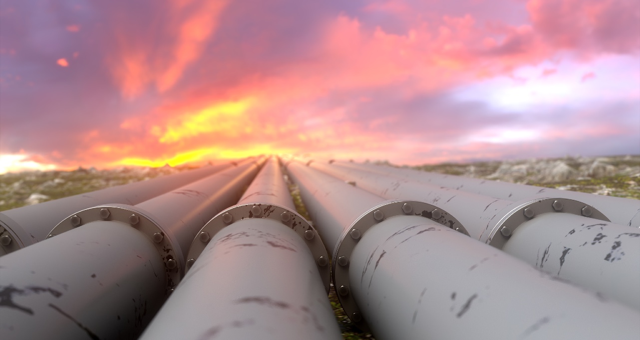 Industrial pipelines and valves on sunset sky background