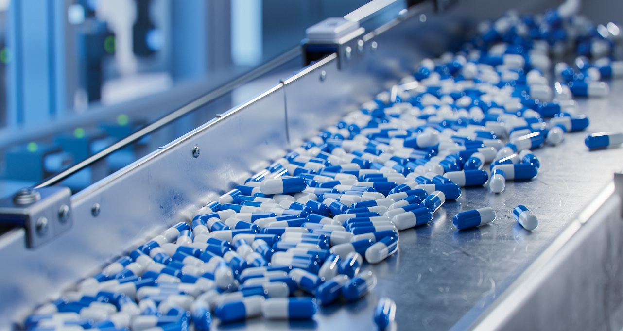 Blue capsules on conveyor at modern pharmaceutical factory