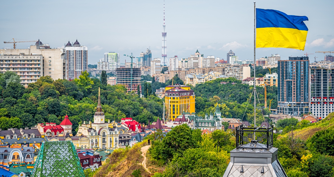 Kyiv, Ukraine cityscape of Kiev and Ukrainian flag waving in the wind