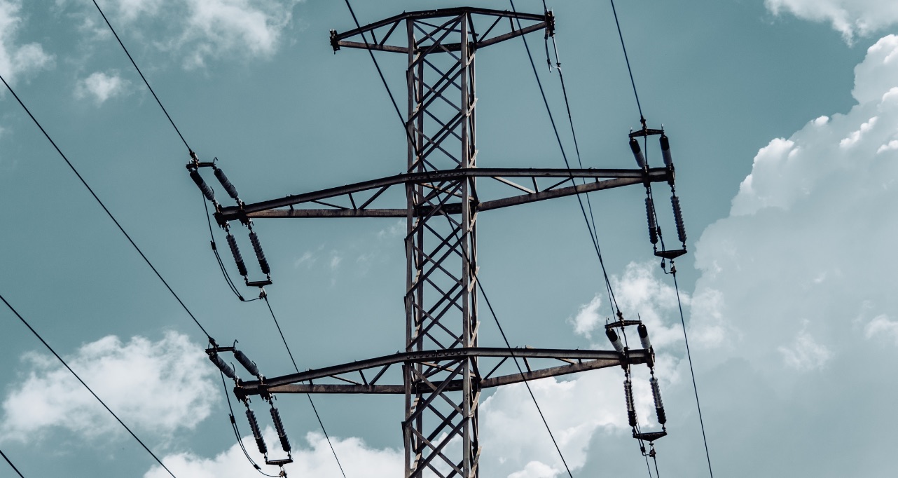 Pylon against a cloudy sky with electric wires. Front side of an electricity tower