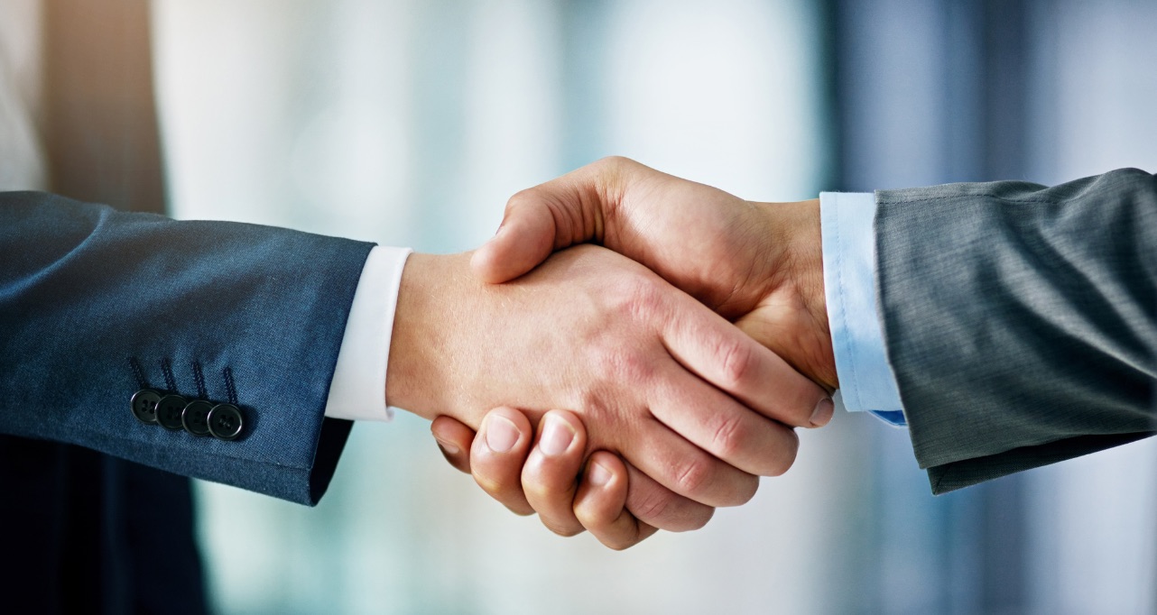 Closeup shot of two businessmen shaking hands in an office