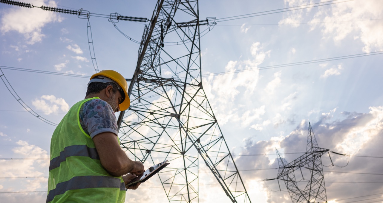 Engineer in front of power plant using digital tablet