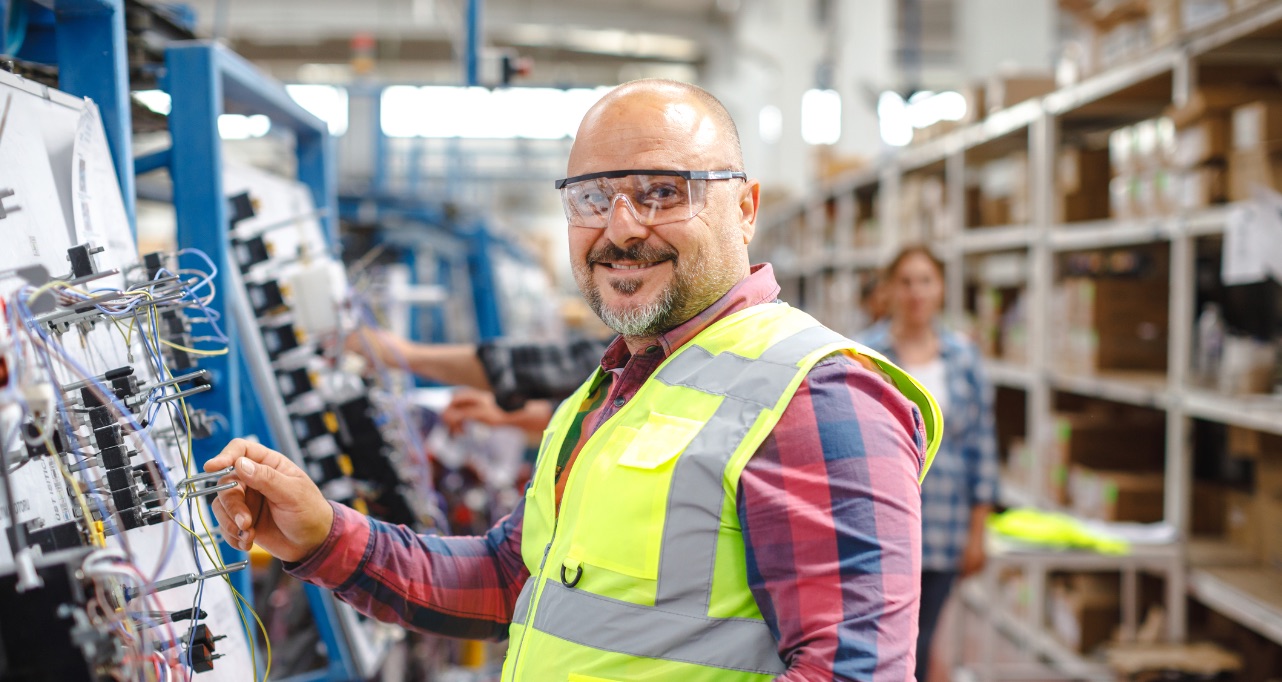 Discover the joy and contentment on the face of a mature manual worker as he carries out his duties at a manufacturing factory.