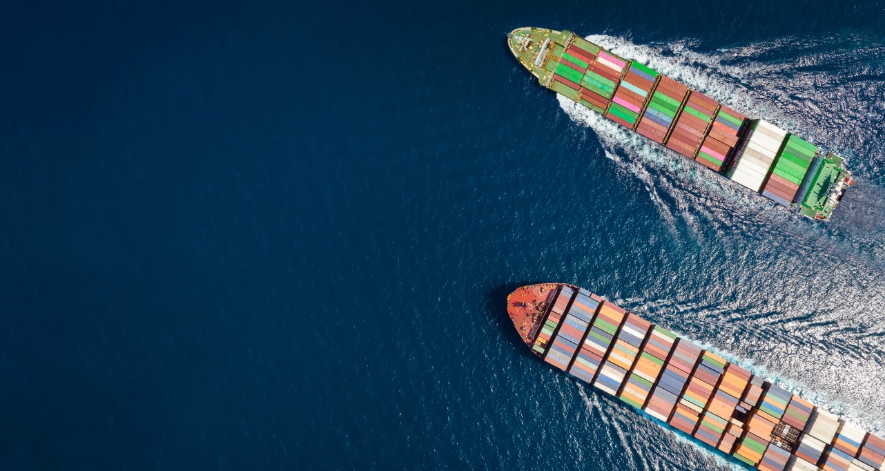 High aerial top down view of two container cargo ships traveling over open ocean