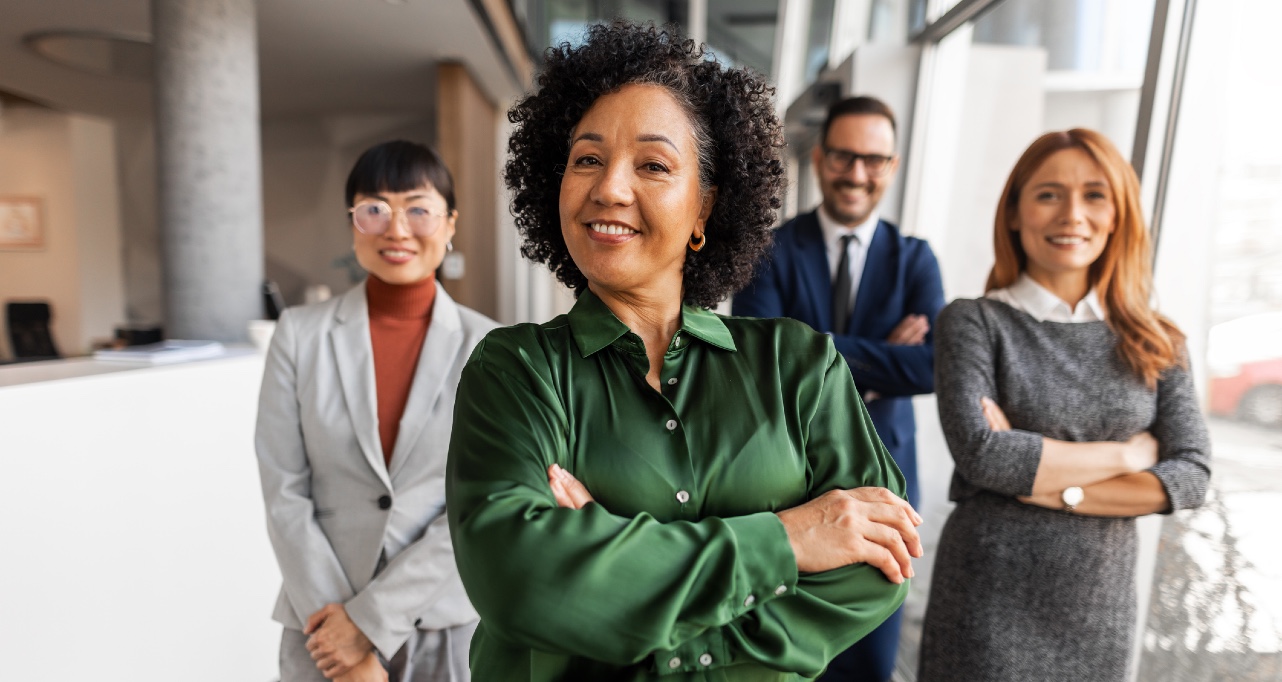 Smiling colleagues dressed in formal attire symbolize success, unity, and professionalism in a supportive corporate environment.